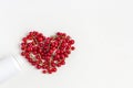 Fresh vitamins berries as shape of heart  from medicine white pill bottle on white background Royalty Free Stock Photo