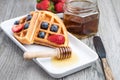 Fresh waffles with honey, strawberries and blueberries Royalty Free Stock Photo