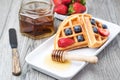 Fresh waffles with honey, strawberries and blueberries Royalty Free Stock Photo