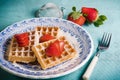 Fresh waffles with strawberries and strainer on table Royalty Free Stock Photo