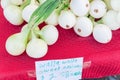 Fresh Walla Walla sweet onion bunches on display with price tags at market stand in Washington, USA