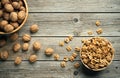 Fresh walnut kernels and whole walnuts in a bowl on rustic old wooden table.