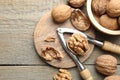 Fresh walnuts and nutcracker on wooden table, flat lay. Space for text Royalty Free Stock Photo