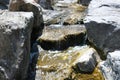 Fresh water creek flow with big boulder rocks and stones close up landscape photo. Rocky river shore natural background Royalty Free Stock Photo