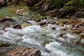 fresh water from the melting glacier that runs fast between the rocks of the stream in the mountains Royalty Free Stock Photo