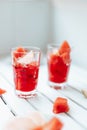 Fresh watermelon refreshing summer cocktail smoothie with lemon and ice in glass jar on white wooden board Vertical Royalty Free Stock Photo