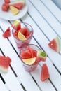 Fresh watermelon refreshing summer cocktail smoothie with lemon and ice in glass jar on white wooden board Vertical Royalty Free Stock Photo