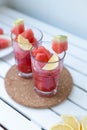 Fresh watermelon refreshing summer cocktail smoothie with lemon and ice in glass mug on white wooden board Royalty Free Stock Photo