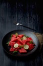 Fresh watermelon salad kept in a black plate on dark background Royalty Free Stock Photo