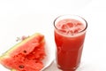 A fresh watermelon smoothie juice drink with ice cubes and a plate full of Slices of watermelon fruit cuts into pieces Royalty Free Stock Photo