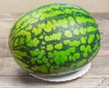 Fresh watermelon, wooden background,ripe striped melon on table,close-up of fresh red watermelon on white plate, sweet Royalty Free Stock Photo