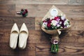 Fresh wedding bouquet, white shoes, boutonniere on wooden background closeup Royalty Free Stock Photo