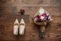 Fresh wedding bouquet, white shoes, boutonniere on wooden background closeup Royalty Free Stock Photo