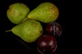 Fresh and wet pears and plums on a black background. Water drops on fruits Royalty Free Stock Photo