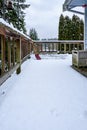 Fresh wet snow on a cedar deck, with snow shovel, view of snow-covered neighborhood