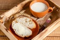 Fresh wheat flour bread with butter and milk in a tray on a wooden background Royalty Free Stock Photo