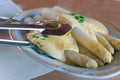 Fresh white asparagus from Beelitz, which is still steaming, on a plate with sauce hollandaise and asparagus tongs Royalty Free Stock Photo