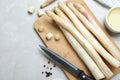 Fresh white asparagus, knife and cutting board on grey marble table, flat lay Royalty Free Stock Photo