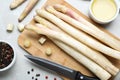 Fresh white asparagus, knife and cutting board on marble table, flat lay Royalty Free Stock Photo