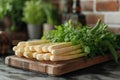 Fresh white asparagus and ramson leaves on chopping board
