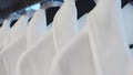 Fresh white bathrobes hanging on rack indoors Royalty Free Stock Photo