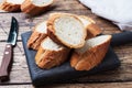 Fresh white bread baguette cut slays on a wooden cutting Board