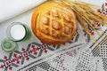 Fresh white bread, salt in a glass jar and rye on background embroidered towel