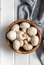 Fresh white champignon mushrooms in wooden bowl