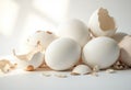 Fresh white eggs with broken shells scattered on a light background Royalty Free Stock Photo