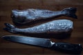 Fresh white fish pollock displayed on chopping board with knife Royalty Free Stock Photo
