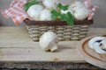 Fresh white mushrooms champignon in brown basket on wooden background. Top view. Copy space Royalty Free Stock Photo