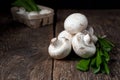 Fresh white mushrooms champignon in brown bowl on wooden background. Top view. Royalty Free Stock Photo