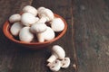 Fresh white mushrooms champignon in brown bowl on wooden background. Top view. Copy space. Royalty Free Stock Photo