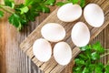 Fresh white raw chicken eggs with parsley on an old wooden table. Royalty Free Stock Photo