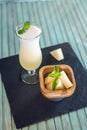 Fresh white smoothie in a glass with sliced pieces of melon and mint on a blue wooden background. Summer cool drinks Royalty Free Stock Photo