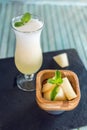 Fresh white smoothie in a glass with sliced pieces of melon and mint on a blue wooden background. Summer cool drinks Royalty Free Stock Photo