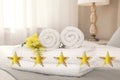 Fresh white towels with flower on bed in five star hotel room