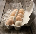 Fresh whole brown eggs in paper packaging on a gray wooden background, close up Royalty Free Stock Photo