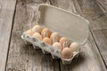 Fresh whole brown eggs in paper packaging on a gray wooden background, close up Royalty Free Stock Photo