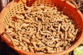 Fresh whole dry turmeric stored in a basket for sell in a market stall