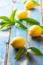 Fresh whole lemons wish leaves on wooden old blue background