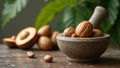 Fresh whole nutmeg on stone mortar with split nutmeg fruit and tree in background Royalty Free Stock Photo