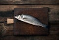 fresh whole sea bass fish on brown wooden cutting board Royalty Free Stock Photo