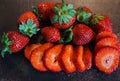 Fresh whole and sliced strawberries on a dark table Royalty Free Stock Photo