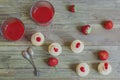 Fresh wholesome strawberry smoothie or juice in glass and meringue cream with fresh strawberries in waffle cup on white plate on