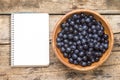 Fresh wild berries with blank recipe book on wood background. Royalty Free Stock Photo