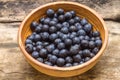 Fresh wild berries in clay bowl on wooden background. Royalty Free Stock Photo