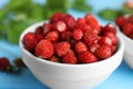 Fresh wild strawberries in bowl on light blue table, closeup Royalty Free Stock Photo