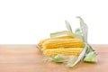 Fresh yellow cobs of maize with kernels ( corn ) on wooden table on white background with space for text Royalty Free Stock Photo