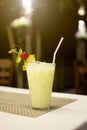 Fresh yellow cocktail with ice and pineapple, lemon slice standing on the table, alcoholic beverages Royalty Free Stock Photo